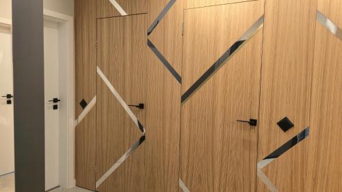 eine Holzwand mit einer Uhr drauf in der Unterkunft LUXURY Designer Apt I Meters to Gondola Lift I Sleeps 6 I Pool & Parking I in Bansko