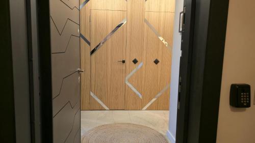 ein Badezimmer mit einer Dusche und einer Holztür in der Unterkunft LUXURY Designer Apt I Meters to Gondola Lift I Sleeps 6 I Pool & Parking I in Bansko