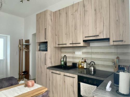 a kitchen with wooden cabinets and a counter top at Patak & Stone apartman in Szentendre