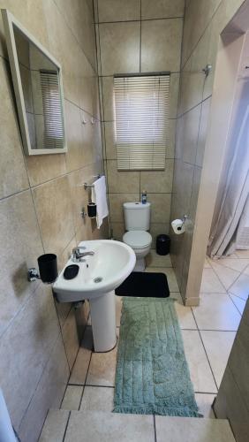 een badkamer met een witte wastafel en een toilet bij Sunnyridge Sky East London in East London