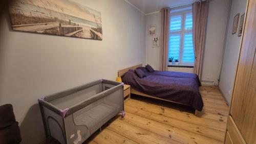 een kleine slaapkamer met een bed en een raam bij Sarantis Apartment in Old Town Gdansk in Gdańsk