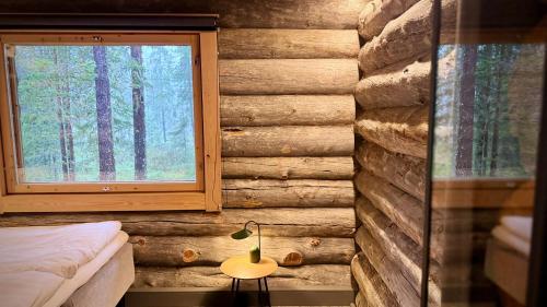 een slaapkamer in een blokhut met een raam bij Kelokurki - The Luxury Lodge Where Serenity Meets the Northern Lights in Levi