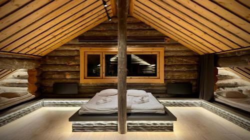 een kamer met een bed in een houten huis bij Kelokurki - The Luxury Lodge Where Serenity Meets the Northern Lights in Levi