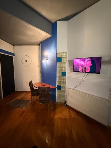 a room with a table and a tv on a wall at Blue Note in Mytilini