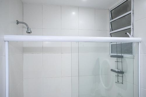 ein weißes Bad mit einer Dusche und einer Glastür in der Unterkunft Studio Solar de Copacabana Vista Mar in Rio de Janeiro