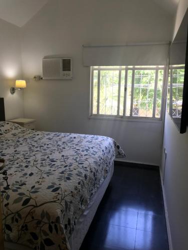 ein Schlafzimmer mit einem Bett und zwei Fenstern in der Unterkunft Duplex SM in San Juan