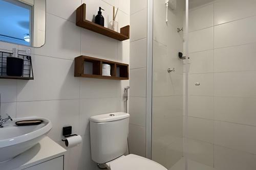 um banheiro branco com um vaso sanitário e uma pia em O mais completo Studio com sacada prox Tokio Marine Hall em São Paulo