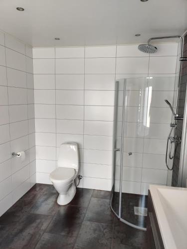 ein weißes Badezimmer mit Toilette und Dusche in der Unterkunft Gamla Hjälmarvägen 10 in Örebro