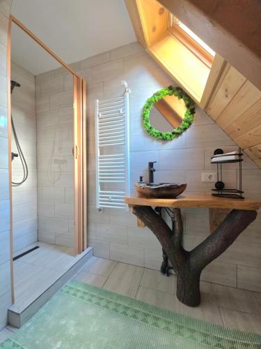 a bathroom with a table with a tree in it at Casuta Armonia in Moisei