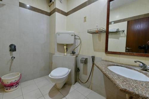 a bathroom with a toilet and a sink and a mirror at Hotel Blue Star - Paharganj Delhi in New Delhi
