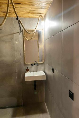 a bathroom with a sink and a mirror at Chatka Wagabundy in Wola Michowa