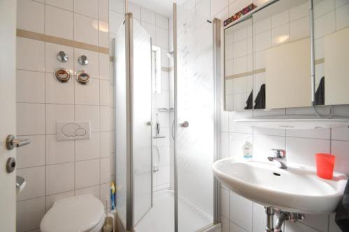 a bathroom with a shower and a sink and a toilet at Fewo Gestrandet in Norderney