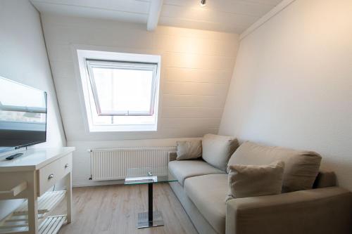 a living room with a couch and a window at Kaffeehaus - Fewo 3 in Norderney