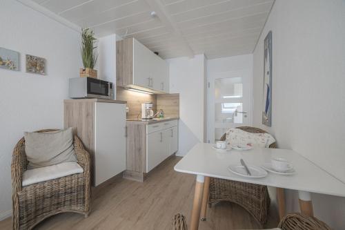 a small kitchen with a white table and chairs in a room at Kaffeehaus - Fewo 3 in Norderney