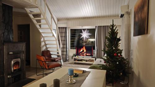 a living room with a christmas tree and a fireplace at Villa Jokiranta in Lapland in Ranua