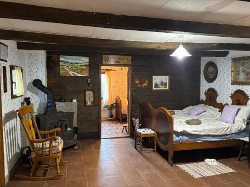 een slaapkamer met een bed en een kamer met een open haard bij Hiža Bake Veronike in Hrašćina