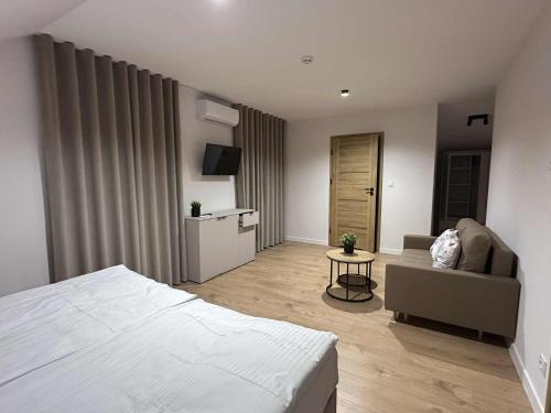 a bedroom with a bed and a couch and a table at Widokówka Radostowa 