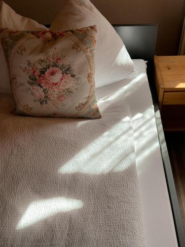 a white bed with a pillow on top of it at Hotel Harder Minerva in Interlaken
