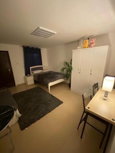 a large living room with a bed and a desk at Simple studio in Abu Dhabi in Abu Dhabi