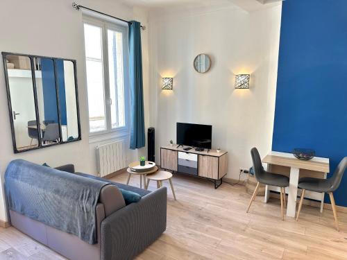 a living room with a couch and a table at Le Bleu Salonais - Centre ville in Salon-de-Provence