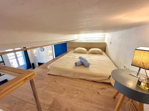 a large bed in a room with a table at Le Bleu Salonais - Centre ville in Salon-de-Provence