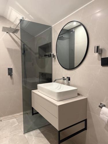 a bathroom with a sink and a mirror at Valmont Luxury Chalet in Glozhene