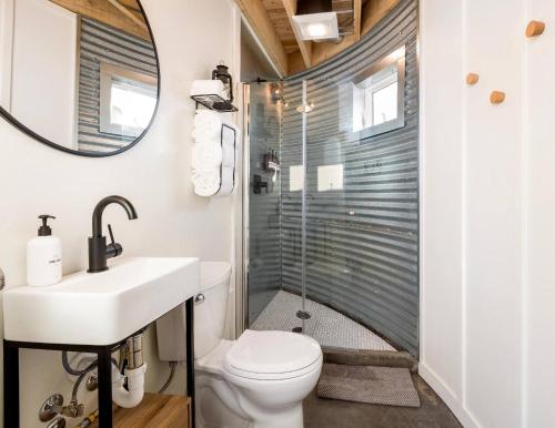 a bathroom with a shower and a toilet and a sink at Clark Farm Silos - 5 Silo Mountain View Retreat in Kalispell