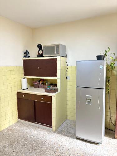 a small kitchen with a refrigerator in a room at Casona el Sol in Veracruz