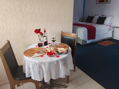 カンポス・ド・ジョルドンにあるKitnet Privativa no Portal de Campos do Jordãoの白いテーブルクロスとワイングラス付きのテーブル