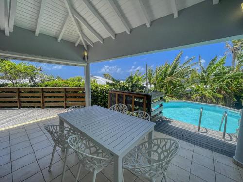 a patio with a table and chairs and a swimming pool at GPSA82 - 4 pax in Fouché