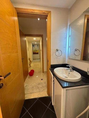 ein Badezimmer mit Waschbecken und Spiegel in der Unterkunft Opera413 Spacious & Central in Muscat