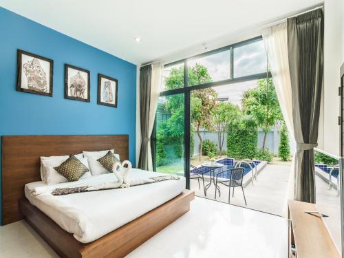 1 dormitorio con paredes azules y ventana grande en Boutique Pool Villa, en Mae Nam