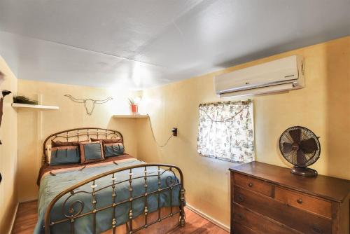 ParksにあるRustic Adventure w Historic Log Cabin Forest Views 20 minutes from Flagstaff Now with Wi-Fiのベッドとドレッサーと窓のある寝室