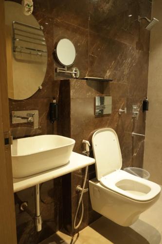 a bathroom with a toilet and a sink at Hotel Amber Inn - 800m from Prayagraj Junction in Prayagraj
