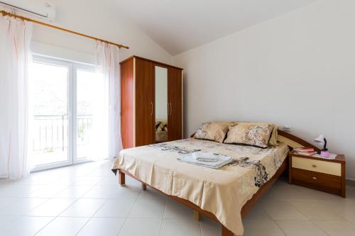 een slaapkamer met een bed en een groot raam bij Apartments Sofia in Sutomore