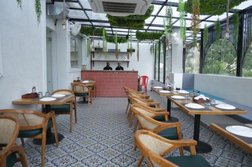 a restaurant with wooden tables and chairs and a counter at Hotel Amber Inn in Prayagraj
