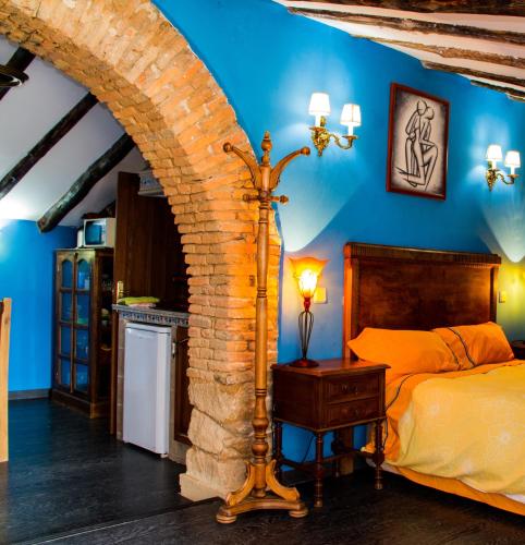 a bedroom with a bed and a brick wall at Casa Tictágora in Plasenzuela