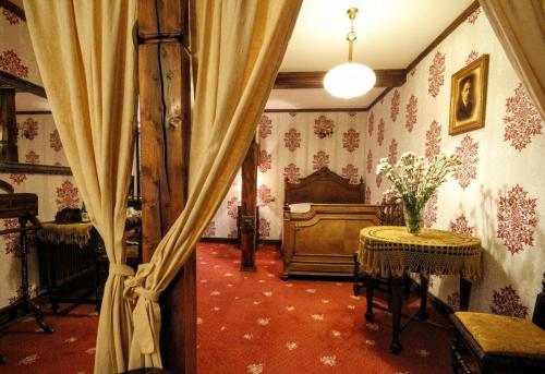 a room with a curtain and a table with flowers at Kiermusy Dworek nad Łąkami in Kiermusy