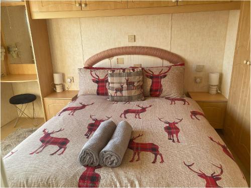 a bed with a bedspread with deer on it at The Wee Sprout in Stranraer