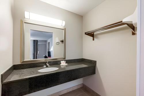 a bathroom with a sink and a mirror at Iberia House & Suites in New Iberia