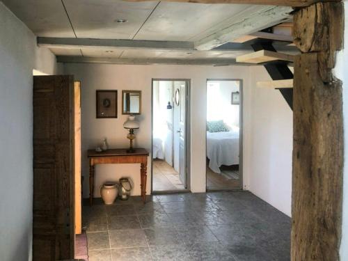 a room with a bedroom with a bed and a table at Traditional Scanian Farmhouse Near Sandhammaren Beach in Löderup