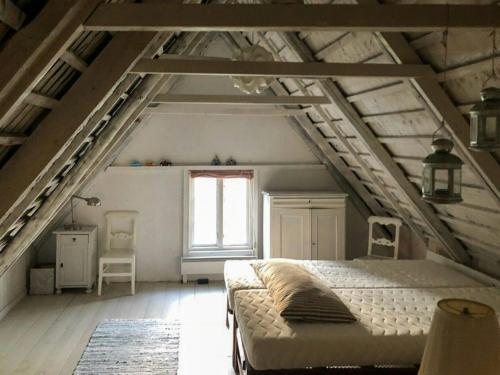 a bedroom with a large bed in a attic at Traditional Scanian Farmhouse Near Sandhammaren Beach in Löderup