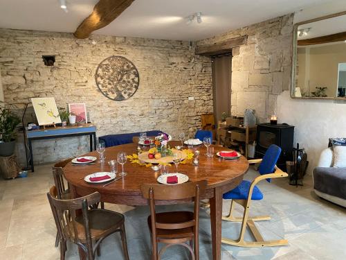 Cense des Possibles - chambre Forêt 4 personnes في Darcey: غرفة طعام مع طاولة وكراسي خشبية