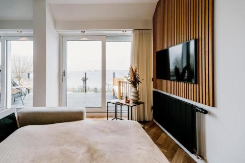 a bedroom with a large bed and a large window at Lake House 10 - 4 Person Lake view apartment! in Offingawier