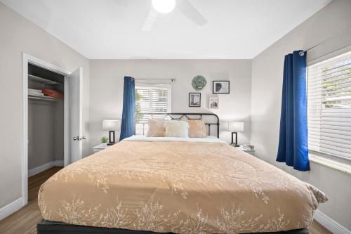 Un dormitorio con una cama grande con cortinas azules. en The Leeward Apartments By Lowkl, en Fort Lauderdale