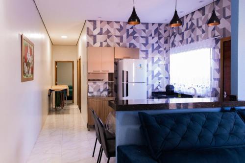 a kitchen and living room with a blue couch at Casa Acqua Beach in Vilhena