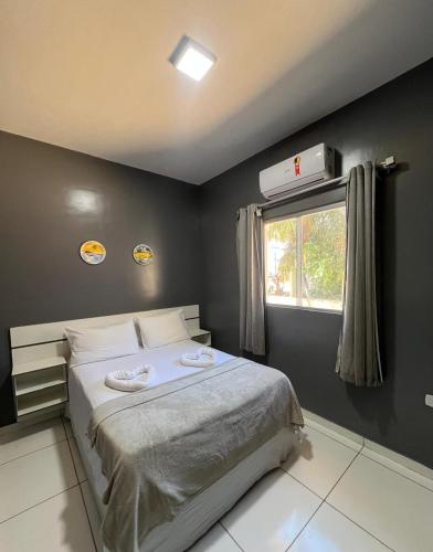 un dormitorio con una cama y una ventana en Pousada Praia Bela, en Maragogi