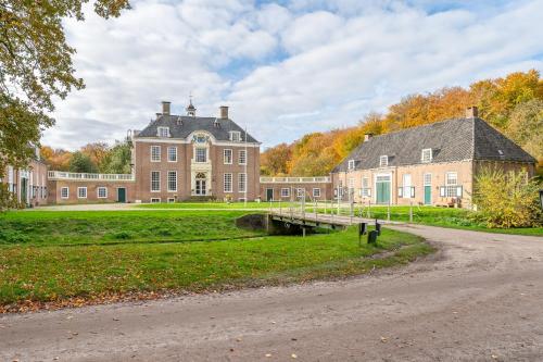 Un gran edificio con un puente delante. en De Zwaluwenburg, en 't Harde
