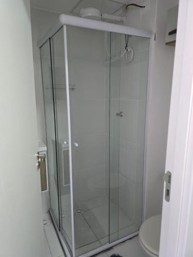 a glass shower in a bathroom with a toilet at Full studio, TV, washing machine, microwave in Sao Paulo