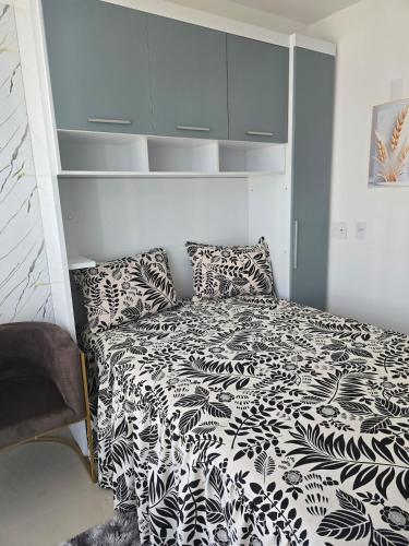 a bedroom with a black and white bed and shelves at Full studio, TV, washing machine, microwave in Sao Paulo